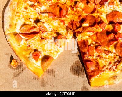 italian pizza pepperoni on cardboard box illuminated by evening sun Stock Photo