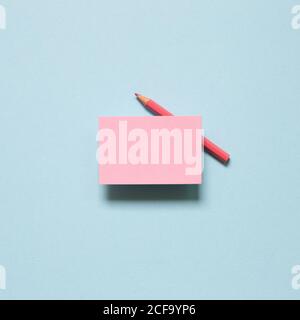 Pink memo paper, sticky notes with colored pencil on blue background. top view, copy space Stock Photo