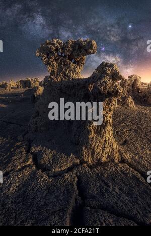 Majestic scenery of volcanic drought terrain with porous rocks and colorful Milky Way on background Stock Photo