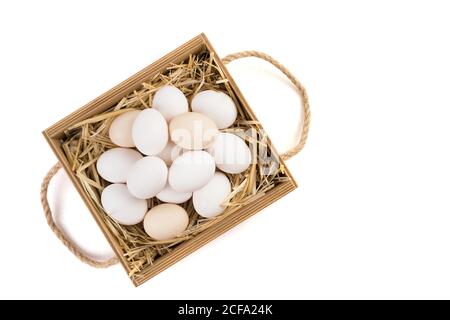 Basket full of chicken eggs lying on straw side View. Stock Photo