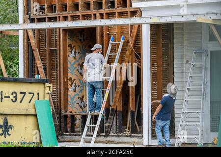 New Orleans, Louisiana/USA - 8/29/2020: Two workers removing siding from old home Stock Photo