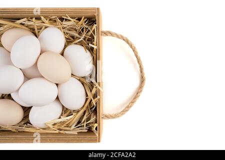 Basket full of chicken eggs lying on straw side View. Stock Photo