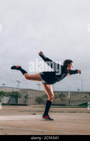 Female hip hop dancer in active wear striking pose outdoors Stock Photo