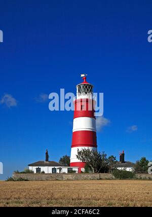 A view of the independently operated Lighthouse with old keepers cottages on the North Norfolk coast at Happisburgh, Norfolk, England, United Kingdom. Stock Photo