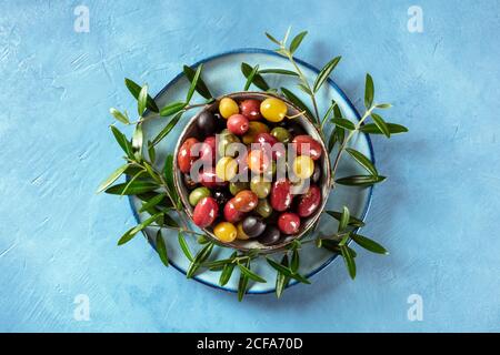 Olives. A variety of green, black and red olives, with leaves, overhead shot Stock Photo