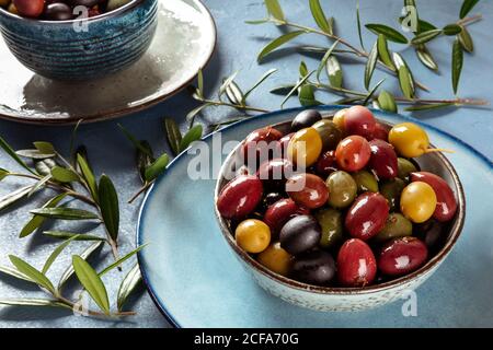 Olives. A variety of green, black and red olives, with leaves Stock Photo