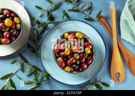 Olives. A variety of green, black and red olives, with leaves, shot from the top Stock Photo