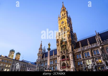 New Town Hall (featuring clock tower and Glockenspiel), domed towers of Frauenkirche (left), Marienplatz, Munich, Germany