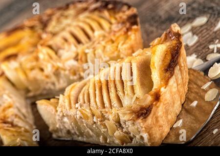 From above of delicious tart with apple slices in almond leaves on wooden table Stock Photo