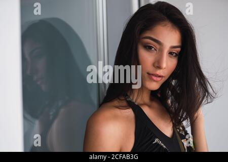 Beautiful passionate brunette Hispanic Woman in black wear looking at the camera Stock Photo