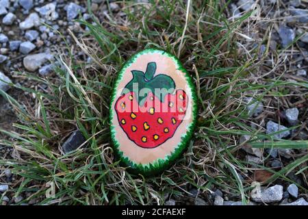 Painted hiking stone is left on the walking path for passersby to see. Stock Photo