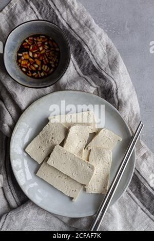 Delicious dish with fried tofu in soy sauce with green onion Stock Photo