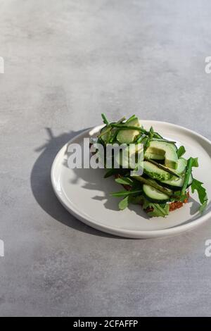 Delicious toast with fresh vegetables and herbs on plate Stock Photo