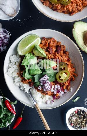 Served chili with rice and vegetables on table Stock Photo