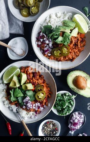 Served chili with rice and vegetables on table Stock Photo