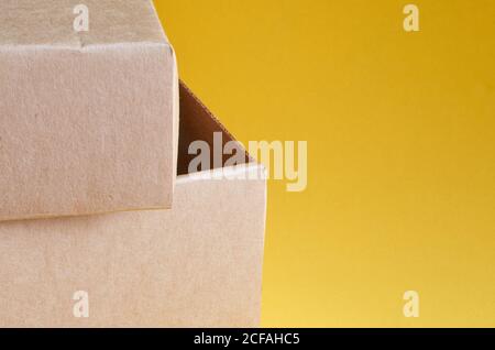 Corner of a brown cardboard box close up on a yellow background Stock Photo