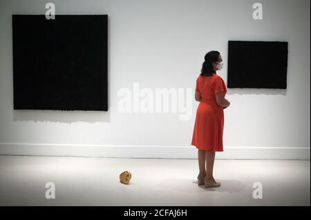 Malaga, Spain. 04th Sep, 2020. A visitor wearing a face mask stands in front of a painting during the exhibition 'Ergo Sum' at Contemporary Art Centre.Mexican artist, Bosco Sodi arrives with around 40 works such as black monochromatic paintings in different formats and gold sculptures. The artist is known for his use of raw, natural materials to create large-scale textured paintings and objects. The exhibition will run in Malaga from 04 September to 06 December 2020. Credit: SOPA Images Limited/Alamy Live News Stock Photo