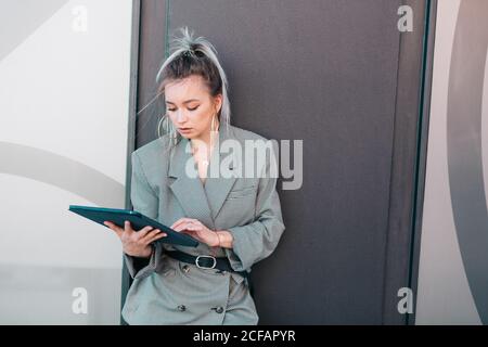 Smart businessWoman with trendy hairstyle and suit using laptop on wall Stock Photo