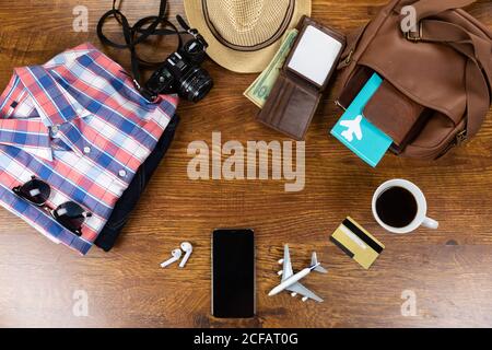 View of a variety of essential travelling items with tablet, smartphone and camera on wooden table Stock Photo