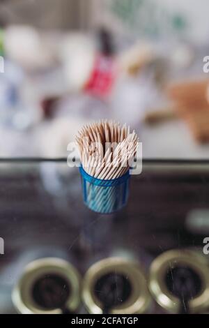 From above wooden stick toothpicks in a small blue container on blurred background Stock Photo