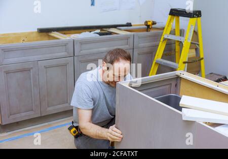 Improvement contractor installing new custom kitchen cabinet furniture decoration new cabinets Stock Photo
