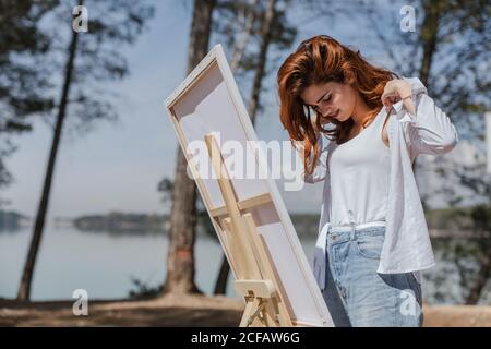 Young Woman putting on her shirt in countryside Stock Photo