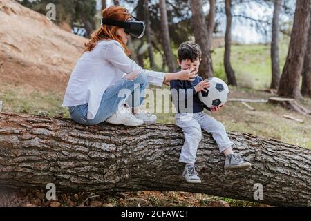 boy looking at mother in VR headset Stock Photo