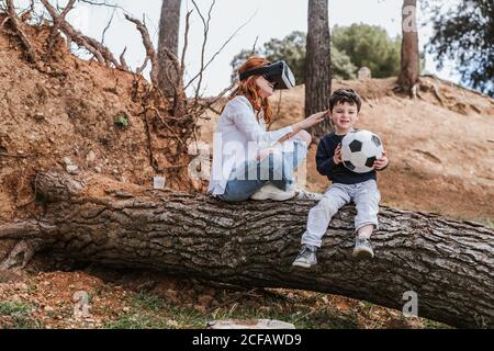 boy looking at mother in VR headset Stock Photo