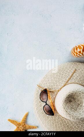Trendy and sunglasses near seashells and starfish for summer vacation concept on plaster surface Stock Photo