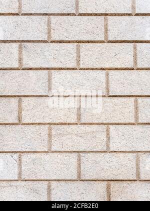 Brickwork of light spotted decorative bricks. Full screen photo. Background texture Stock Photo