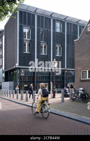 Cyclist rides on the Prinsengracht in front of the Anne Frank House Museum in Amsterdam Stock Photo