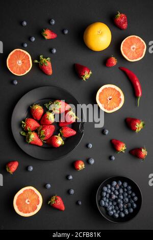 Top view of various fresh fruits for breakfast placed on black background Stock Photo