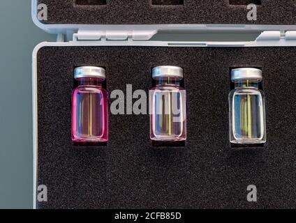 From above closed glass ampoules with scientific samples arranged in black foam rubber case in lab Stock Photo