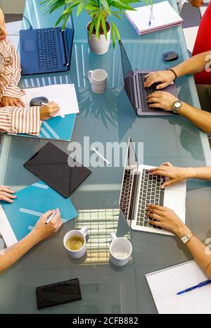 faceless colleagues working at laptops in office Stock Photo
