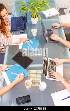 faceless colleagues working at laptops in office Stock Photo