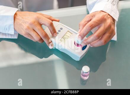 Assistant working in lab with pink liquid Stock Photo