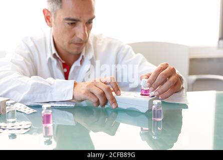 Assistant working in lab with pink liquid Stock Photo