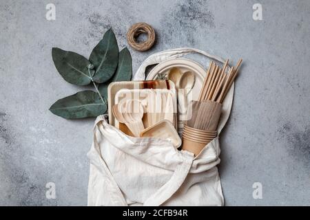 Eco craft paper and wooden tableware. Paper cups, dishes, bag, plates and wooden cutlery in linen bag. Recycling or eco-friendly concept Stock Photo