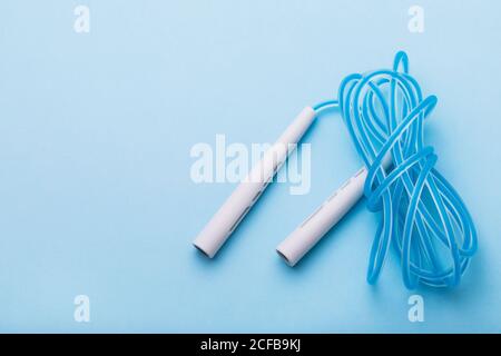 Jump rope on blue background with copy space, top view Stock Photo