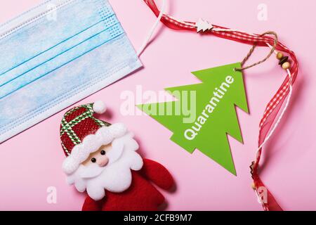 Medical mask and Christmas accessories on a pink background. Quarantine concept Stock Photo