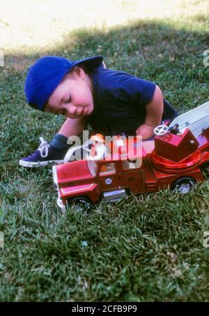 Toddler Boy Playing with Red Fire truck Stock Photo