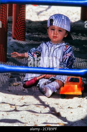 Toddler Boy Playing in Sand with toy truck Stock Photo