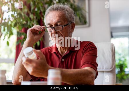 Senior man taking prescription medicine at home Stock Photo