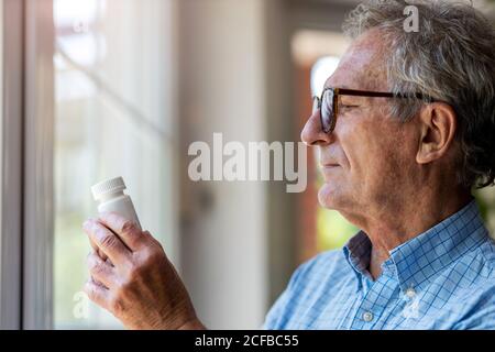 Senior man taking prescription medicine at home Stock Photo