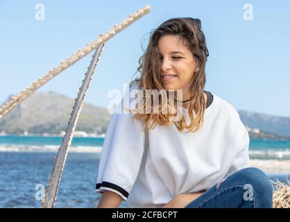 Young Woman sitting near dried plants Stock Photo