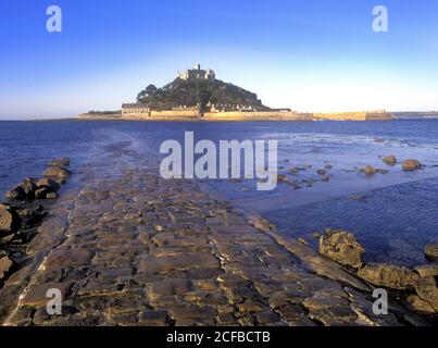 St Michaels Mount castle on a tidal island linked to mainland by man made causeway of granite setts visible at low tide Marazion Cornwall England UK Stock Photo