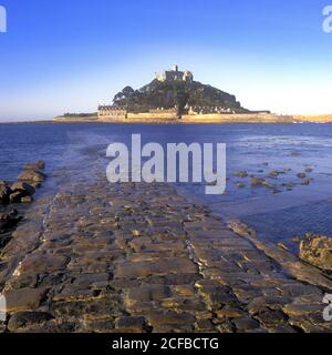 St Michaels Mount castle on a tidal island linked to mainland by man made causeway of granite setts visible at low tide Marazion Cornwall England UK Stock Photo