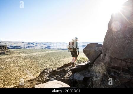 A woman hiking the climbers trail around Sunshine Wall in Echo Basin / Frenchmans Coulee, Eastern Washington, USA. Stock Photo