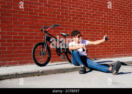 Young happy black male taking selfie near bike Stock Photo