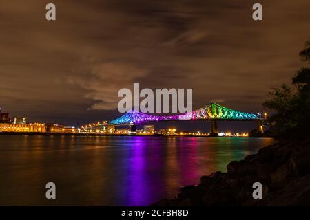 Night Shot the Jacques-Cartier bridge in a rainbow lighting, during the COVID-19 pandemic. Stock Photo